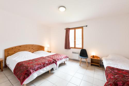 een slaapkamer met 2 bedden en een raam bij La Tour de Guet in Montbrun-les-Bains