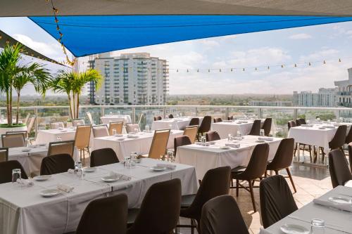 un restaurante con mesas y sillas blancas y vistas en The Circ powered by Sonder, en Hollywood