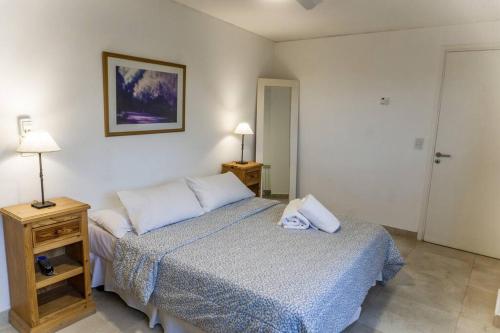 een slaapkamer met een bed en een nachtkastje met 2 lampen bij Moderno Dpto en zona de bodegas in Ciudad Lujan de Cuyo