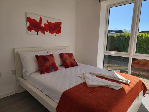a white bed with red pillows and a window at Paradigm Court, Luxury 2-Bedroom Apartment F3, Oxford in Oxford