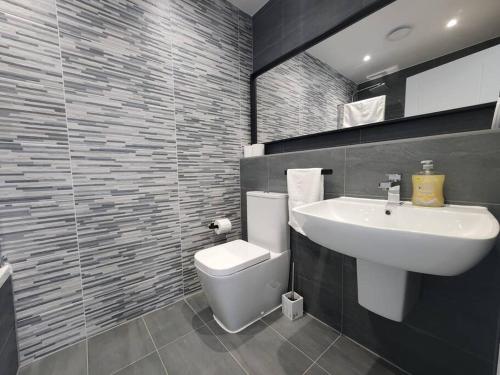 a bathroom with a white toilet and a sink at Paradigm Court, Luxury 2-Bedroom Apartment F3, Oxford in Oxford