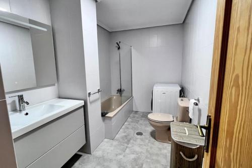 a white bathroom with a toilet and a sink at Piso en Picos de Europa - Riaño Licencia VUT-LE-818 in Riaño