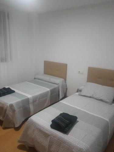 two beds sitting next to each other in a room at Piso bonito y tranquilo in Monachil