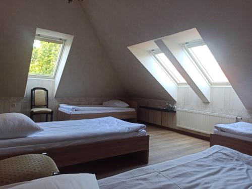 a attic room with two beds and two windows at Bed&Blues in Vilnius