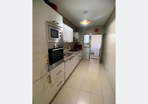 una cucina con elettrodomestici bianchi e un lungo corridoio di Apartment for rent in Marrakech a Marrakech