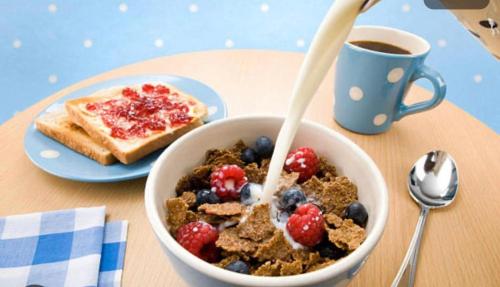 a bowl of cereal and berries next to a plate of toast at Mac’s in Belfast