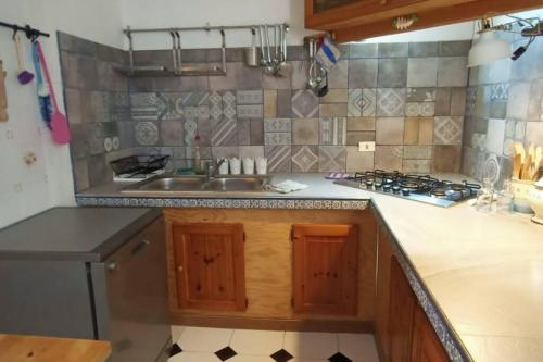 a kitchen with a sink and a stove at Centro Lampedusa via Roma in Lampedusa