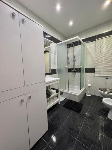 a white bathroom with a sink and a shower at Apartment by the sea in Ika