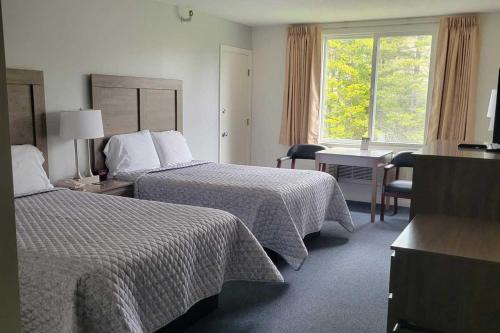 a hotel room with two beds and a window at Kimball Terrace Inn in Northeast Harbor