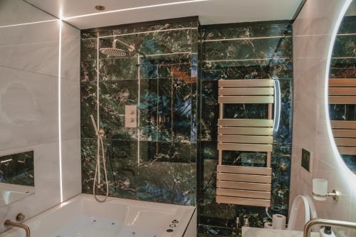 a bathroom with a shower and a bath tub at The Opulence in Bradford
