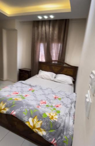 una camera da letto con un letto fiorito di شقة مفروشة فى المهندسين a Il Cairo