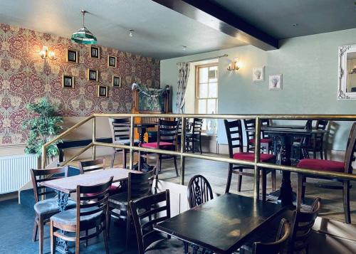 a restaurant with tables and chairs in a room at Mortonhall in Edinburgh