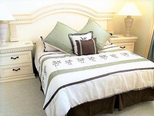 een slaapkamer met een bed met 2 nachtkastjes en 2 tafels bij 6 bedrooms pool home 10 min from Disney in Orlando
