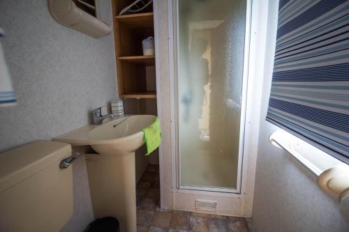 La petite salle de bains est pourvue d'un lavabo et d'une douche. dans l'établissement Great 4 Berth Caravan At Withernsea Sands Ref 79003hg, 