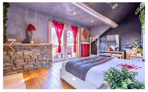 a bedroom with a large bed and a stone wall at La Suite Diamant in Theux