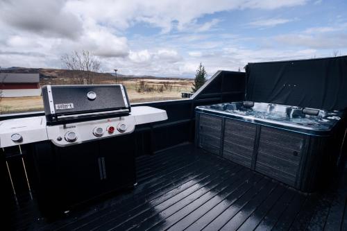 einen Grill und einen Grill auf einer Terrasse in der Unterkunft Golden Circle Luxury Cottages in Selfoss