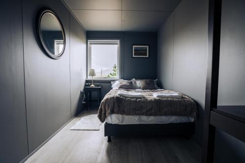 a bedroom with a bed and a mirror and a window at Golden Circle Luxury Cottages Lake View in Selfoss
