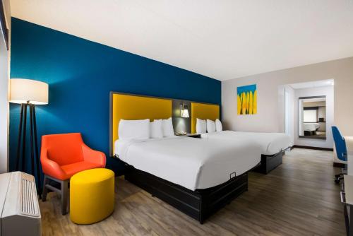 a hotel room with a large bed and a orange chair at Best Western Bordentown Inn in Bordentown