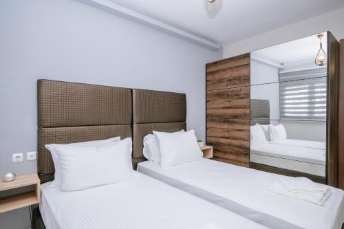 una camera con due letti e uno specchio di Unique1 - Private Lux city apartment a Heraklion