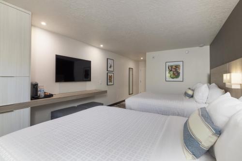 a hotel room with two beds and a flat screen tv at Montclair at Zion in Springdale