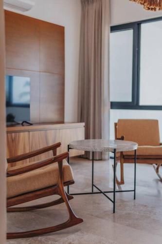a living room with a table and a chair at Villa de lujo frente al mar de Progreso in Progreso