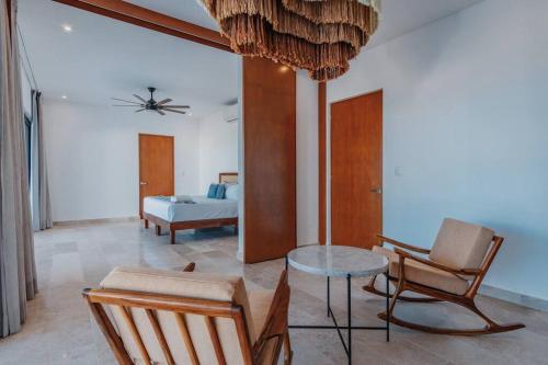 a living room with a chair and a table and a bed at Villa de lujo frente al mar de Progreso in Progreso