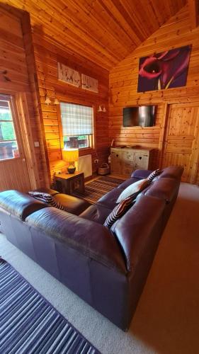 a living room with a large couch in a cabin at 3-Bed Lodge - Sleeps 7 - Hot Tub - Pet Friendly in Skipton