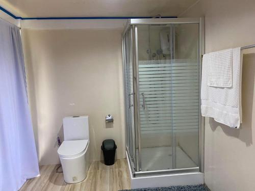 een badkamer met een toilet en een glazen douche bij Azure at Tranquility Bay Beach Resort in Kinabutan