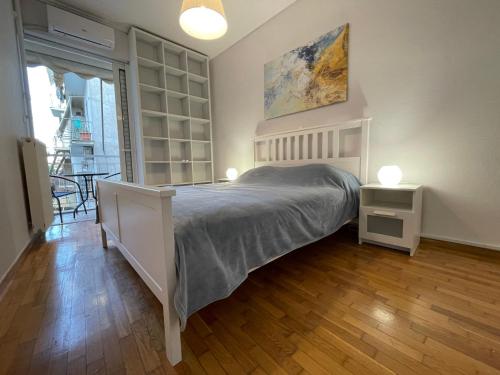 a bedroom with a bed and two lamps on a wooden floor at Traveller's Choice Attiki in Athens