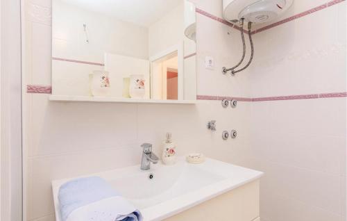 a white bathroom with a sink and a mirror at Beautiful Apartment In Pakostane With 2 Bedrooms And Wifi in Pakoštane