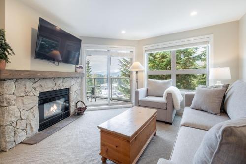 a living room with a couch and a fireplace at The Aspens by Outpost Whistler in Whistler