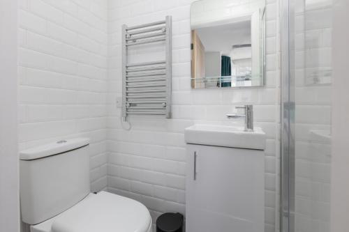 ein weißes Bad mit einem WC und einem Waschbecken in der Unterkunft Charles Alexander Short Stay - TheWestern Blackpool in Blackpool