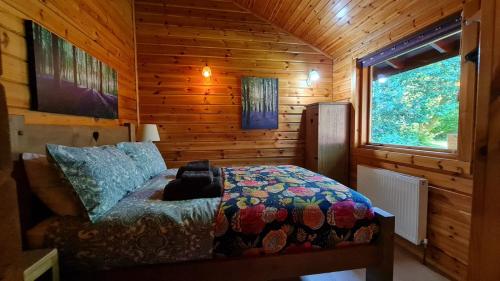 a bedroom with a bed in a wooden cabin at Secluded 3Bed Lodge with hot tub North Yorkshire in Skipton