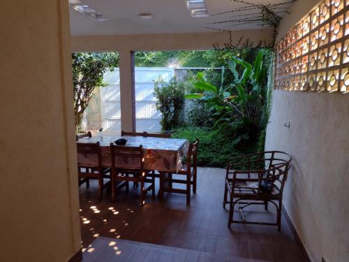 a dining room with a table and chairs on a patio at Suite Hanaki com microondas e frigobar in Ubatuba