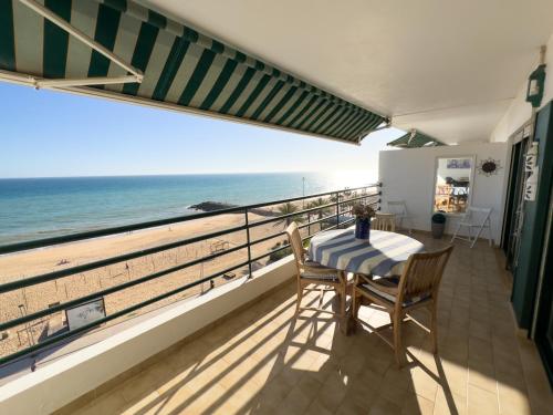 a balcony with a table and chairs and a view of the beach at Ocean Blue II in Quarteira