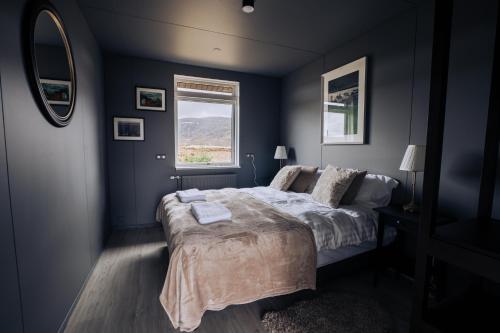 a bedroom with a bed and a window at Golden Circle Luxury Cottages Lake View in Selfoss