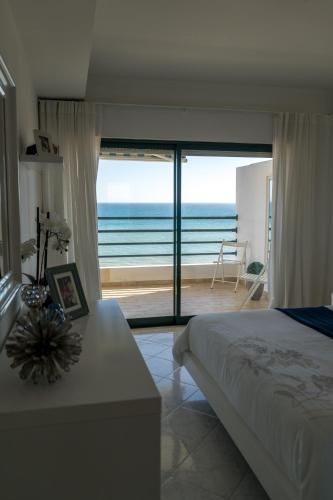 a bedroom with a bed and a view of the ocean at Ocean Blue II in Quarteira