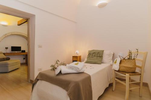 a bedroom with a bed and a chair in a room at Milestones Modern Suite Trullo Jacuzzi Spa & Relax in Alberobello
