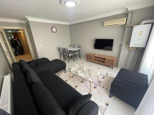 un soggiorno con divano nero e TV di Babil house 1 a Istanbul