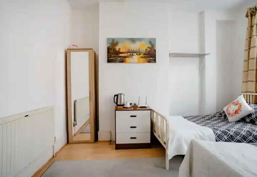 a bedroom with a bed and a mirror at Homestay near Tottenham Hotspur Stadium in London