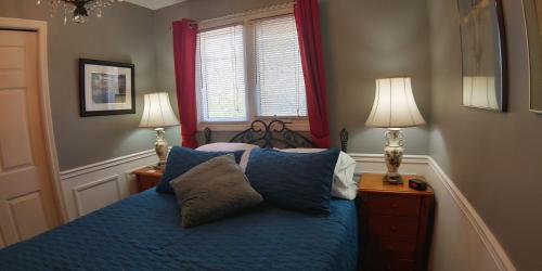 a bedroom with a blue bed with two lamps at BobcaygeonB&B in Kawartha Lakes