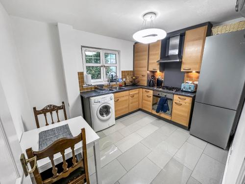 eine Küche mit einem Kühlschrank, einem Geschirrspüler und einem Tisch in der Unterkunft Comfortable 2 Bedroom Flat In The City Centre in Edinburgh