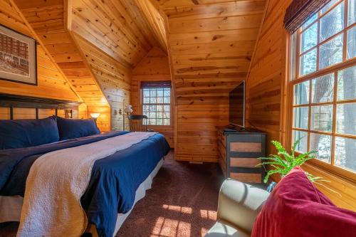 a bedroom in a log cabin with a bed and a tv at Cedarwood Lodge in Saugatuck