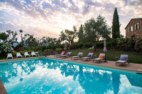 a swimming pool with lounge chairs next to a house at Villa in Agello in Agello
