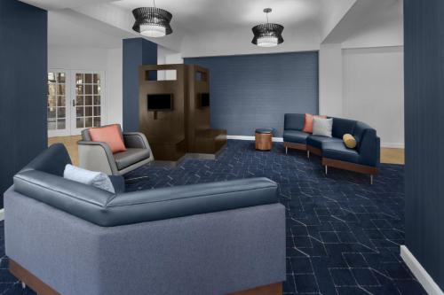 a waiting room with a couch and chairs and a tv at Courtyard by Marriott San Diego Rancho Bernardo in Rancho Bernardo