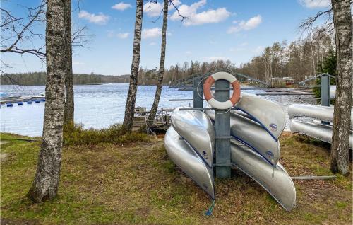 a boat sitting on the grass next to a lake at Stunning Home In Jälluntofta With Sauna in Jälluntofta