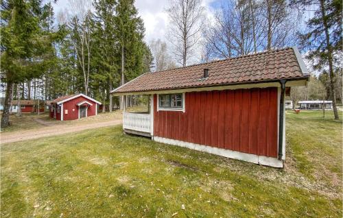 a red building in a field next to a red barn at Stunning Home In Jälluntofta With Sauna in Jälluntofta