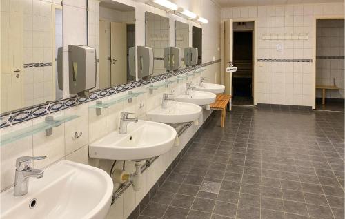 a bathroom with four sinks and a row of mirrors at Stunning Home In Jälluntofta With Sauna in Jälluntofta