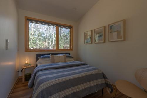 a small bedroom with a bed and a window at Malaya Dunes Walk To Laketown Beach in Holland