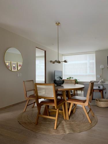 a dining room with a wooden table and chairs at New Apartment in the heart of Polanco in Mexico City